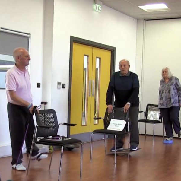 Three people taking part in an ESCAPE-Pain Class and completing leg exercises and stretches