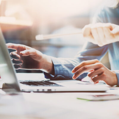 Two colleagues pointing at a laptop screen.