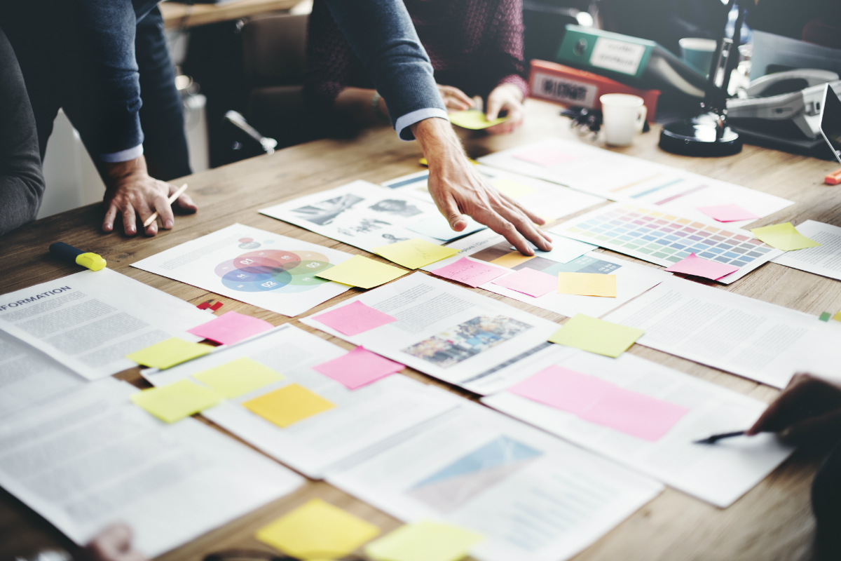 People looking at case studies on a desk