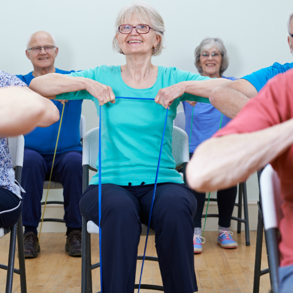 Elderly woman taking part in chair-based exercise class