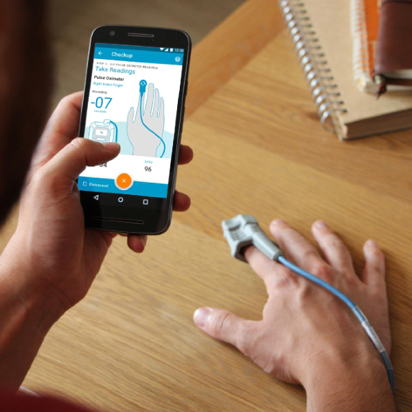 Feebris TechForce19 winner. A man checking his vital signs with a pulse oximeter and mobile phone app.