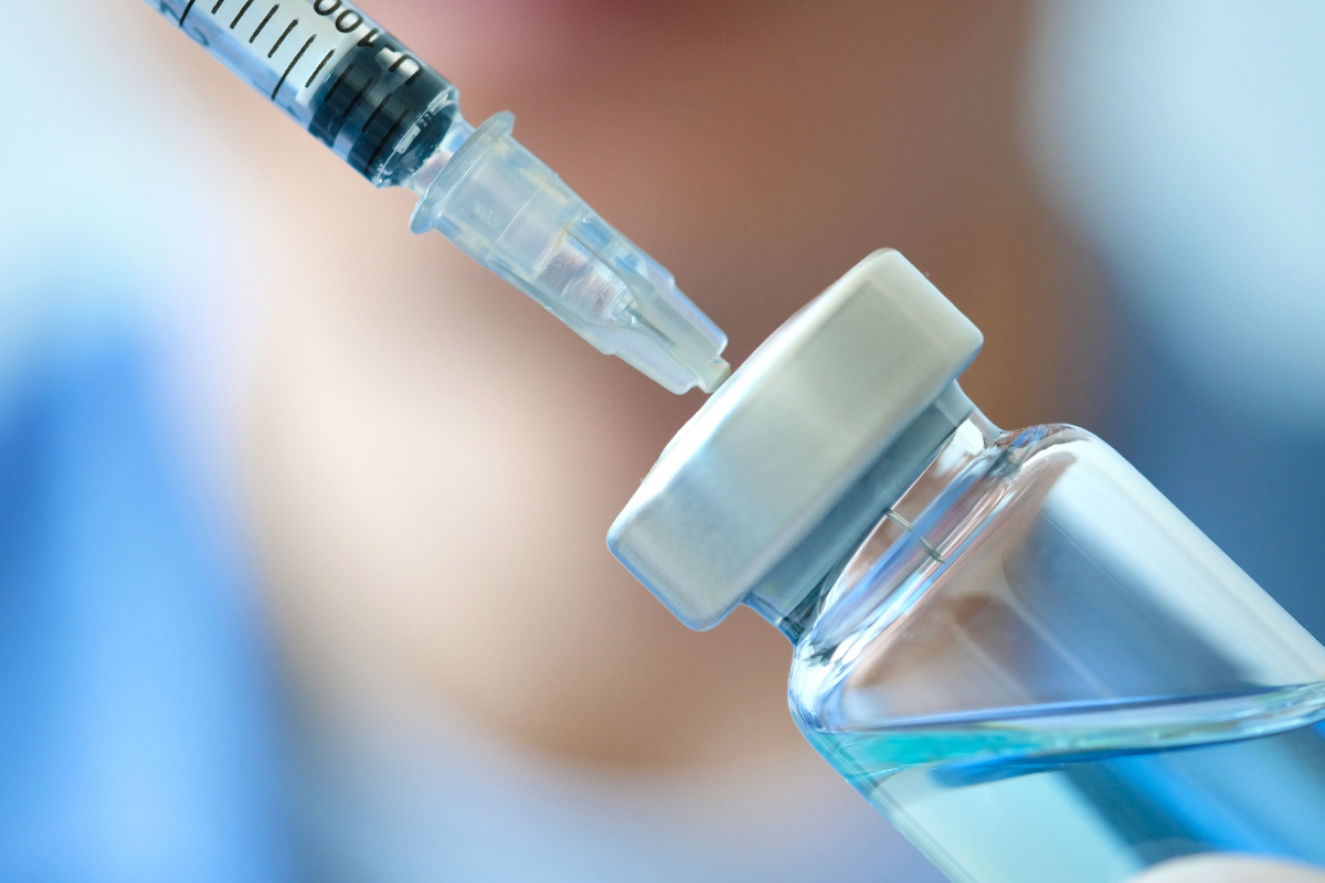 Close up doctor's hand holds a syringe and treatment bottle