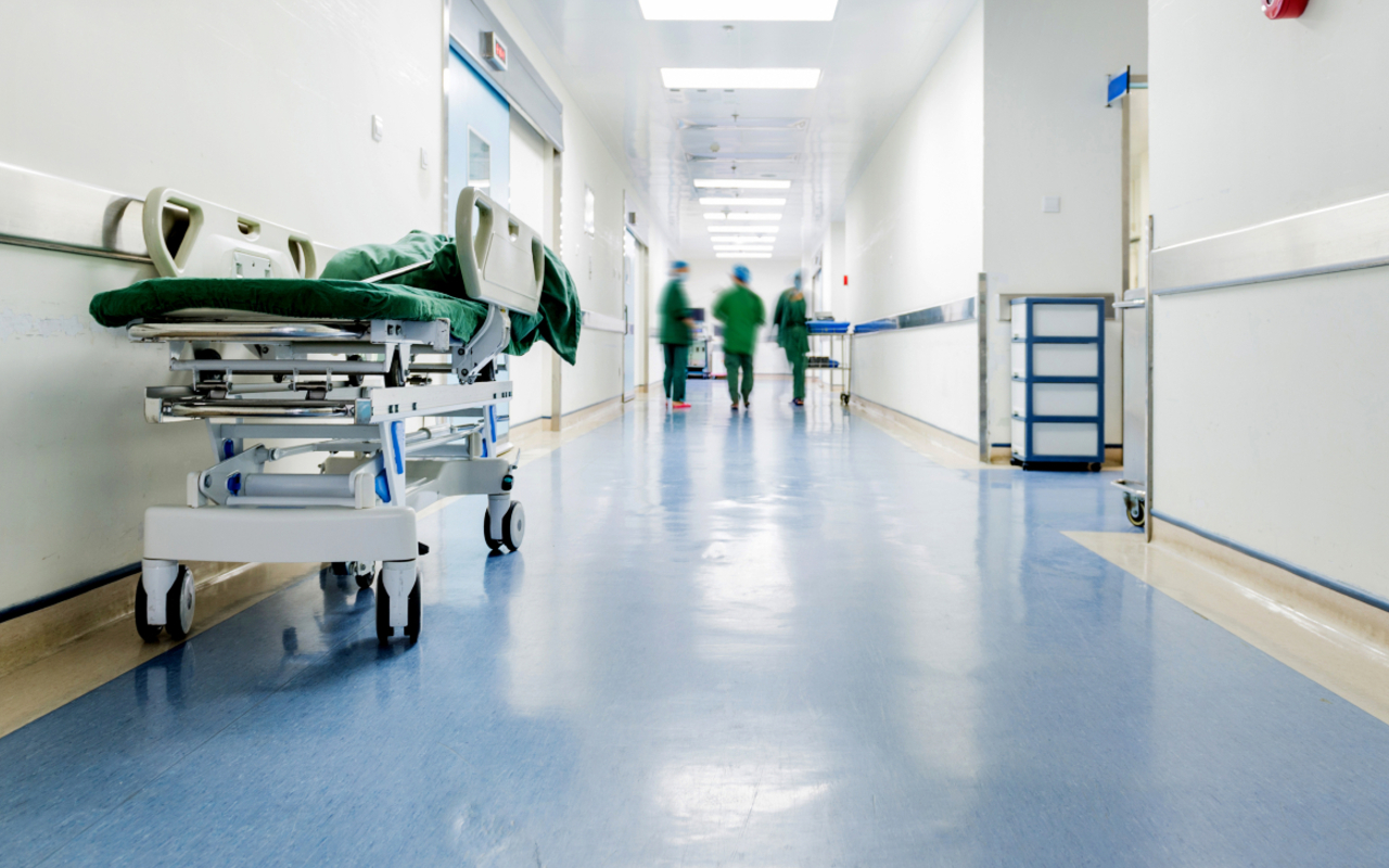 Hospital ward with patient bed & staff.
