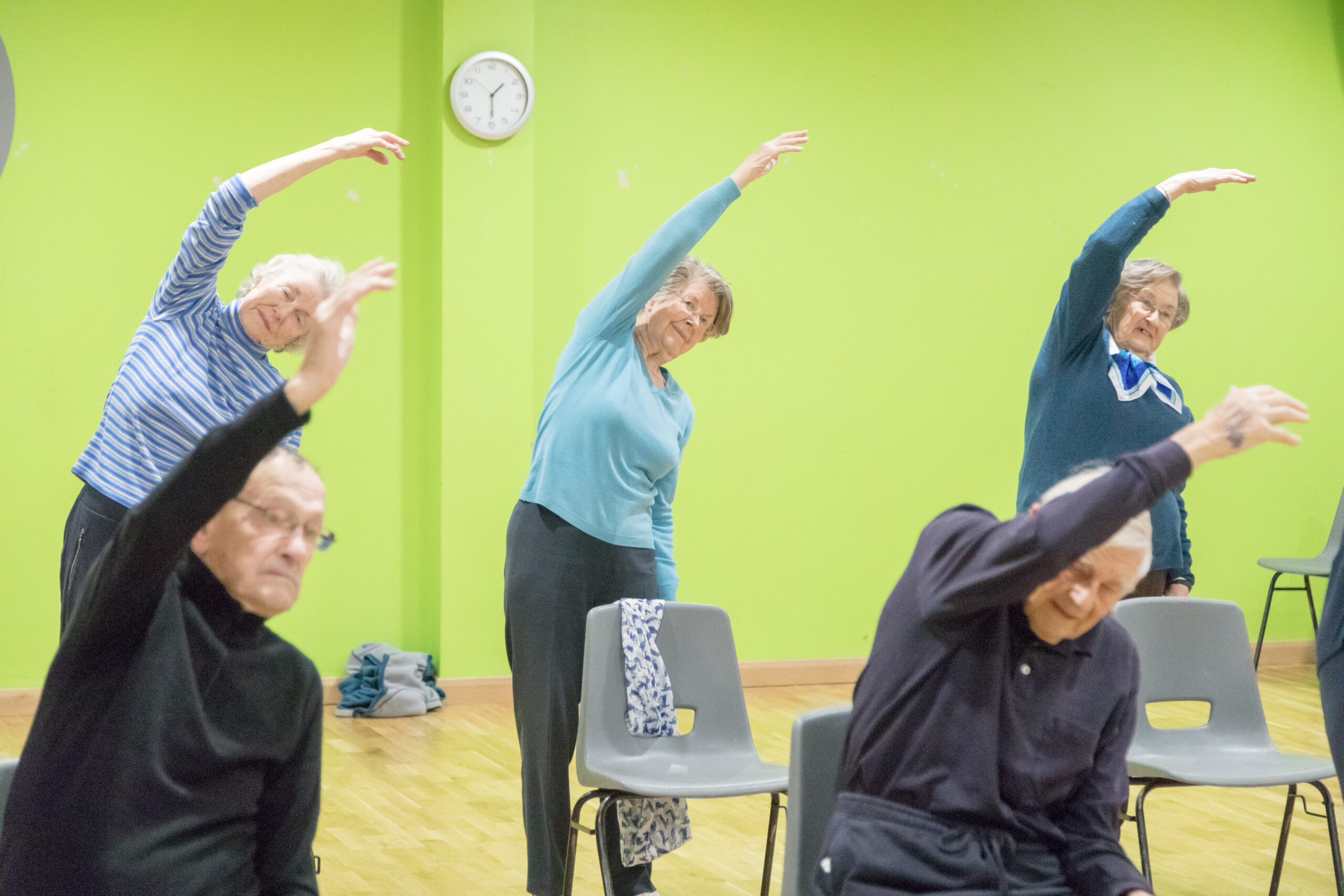 Elderly people exercising in a group.