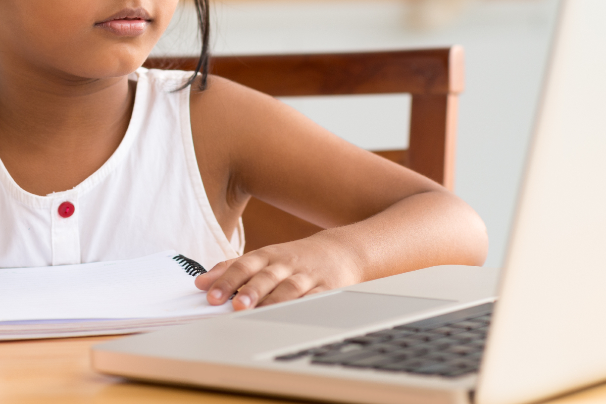 Child sat at a laptop learning.