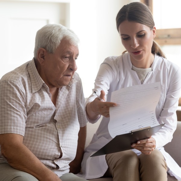 Female medical worker visit old retired male patient